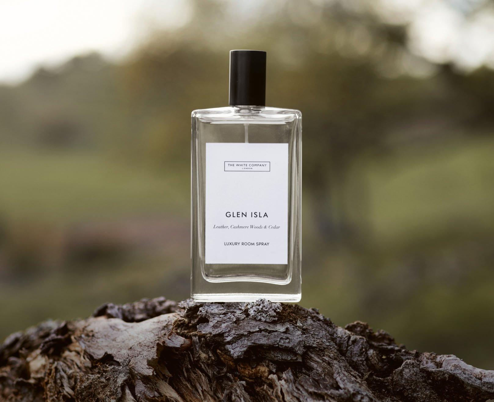 a bottle of perfume sitting on top of a tree stump
